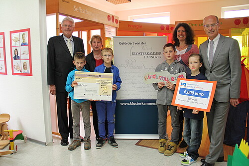 Vier Erwachsene, darunter Klosterkammer-Präsident Hans-Christian Biallas, und vier Kinder bei einer Scheck-Übergabe im Kindermuseum Zinnober.