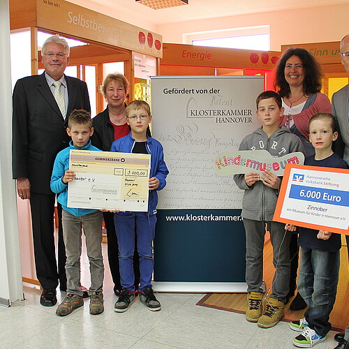 Vier Erwachsene, darunter Klosterkammer-Präsident Hans-Christian Biallas, und vier Kinder bei einer Scheck-Übergabe im Kindermuseum Zinnober.
