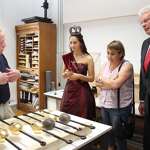 Zwei Frauen und zwei Männer, darunter Klosterkammer-Präsident Hans-Christian Biallas und Hans-Joachim Frey, Leiter der Restaurierungswerkstatt der Klosterkammer, sehen sich vergoldete Kugeln an.