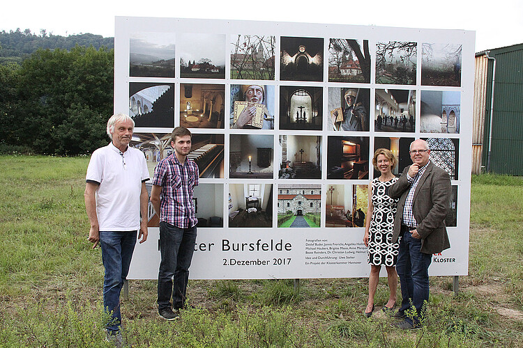 Vor einer großen Foto-Installation mit 28 Einzelbildern aus dem Kloster Bursfelde stehen vier Personen.