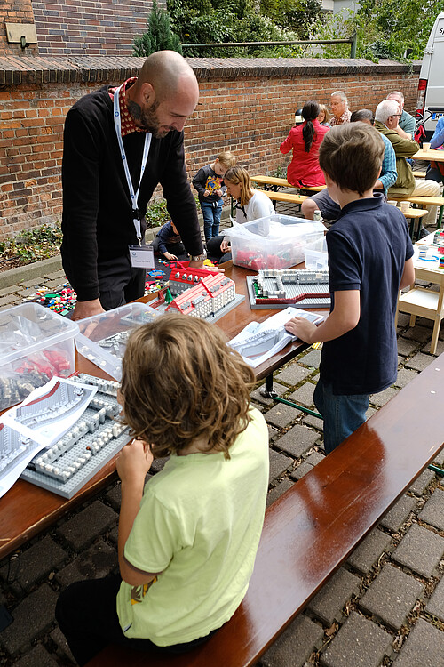 Zwei junge Baumeister versuchen sich am Nachbau der Klosterkammer im Miniaturformat – unter Anleitung von Pascal Lenhard.