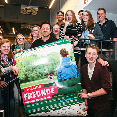 Eine Gruppe von Jugendlichen hält ein Plakat.