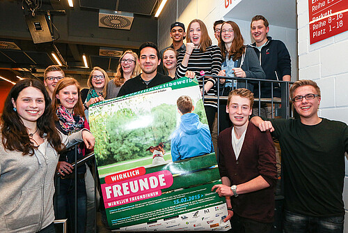 Eine Gruppe von Jugendlichen hält ein Plakat.