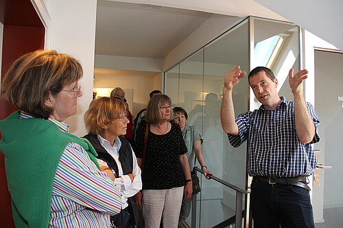 Dr. Tim Wameling, Baudezernent der Klosterkammer, erläutert einer Gruppe von Personen Brandschutzmaßnahmen im Kloster Barsinghausen.