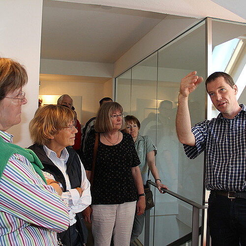 Dr. Tim Wameling, Baudezernent der Klosterkammer, erläutert einer Gruppe von Personen Brandschutzmaßnahmen im Kloster Barsinghausen.