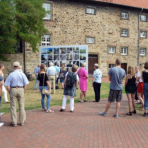 Eine Gruppe von Personen steht vor einer Fotowand.