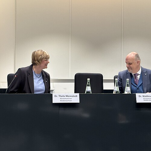 Ein Mann und eine Frau sitzen in einem Raum.