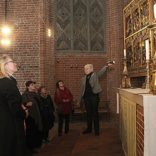 Eine Gruppe von Frauen, darunter Katrin Woitack, Äbtissin des Stifts Fischbeck, steht in einer Kirche vor einem vergolden Bildnis.
