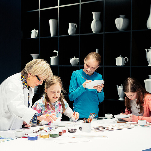 Blick in die Besucherwerkstatt. Kinder malen Porzellan an.