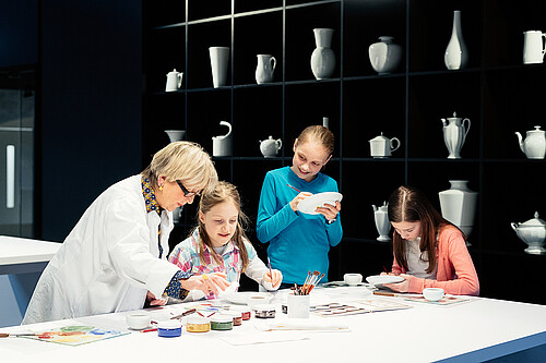 Blick in die Besucherwerkstatt. Kinder malen Porzellan an.