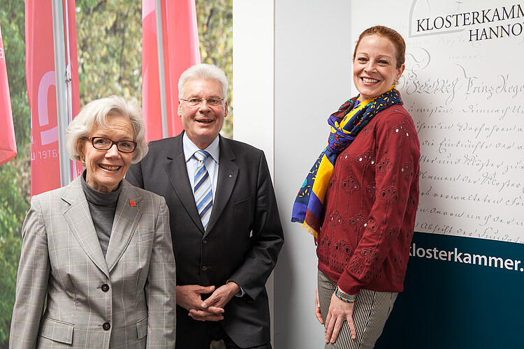 Zwei Frauen und ein Mann, darunter Klosterkammer-Präsident Hans-Christian Biallas, stehen neben einer Tafel der Klosterkammer.