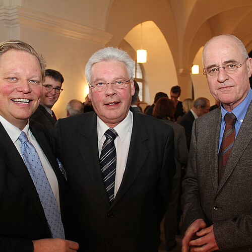 Drei Männer, darunter Klosterkammer-Präsident Hans-Christian Biallas, stehen in einem Raum mit angeleuchtetem Gewölbe.