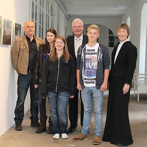 Bärbel Görcke, Äbtissin des Klosters Mariensee, zwei Männer, darunter Klosterkammer-Präsident Hans-Christian Biallas, und drei Jugendliche, stehen auf einem Flur mit Bildern.