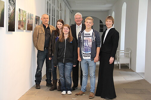Bärbel Görcke, Äbtissin des Klosters Mariensee, zwei Männer, darunter Klosterkammer-Präsident Hans-Christian Biallas, und drei Jugendliche, stehen auf einem Flur mit Bildern.