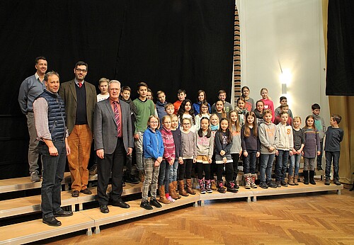 Dr. Stephan Lüttich von der Klosterkammer steht mit Schulleiter und Schülern des Domgymnasiums auf dem dreistufigen Chorpodest