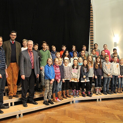 Dr. Stephan Lüttich von der Klosterkammer steht mit Schulleiter und Schülern des Domgymnasiums auf dem dreistufigen Chorpodest
