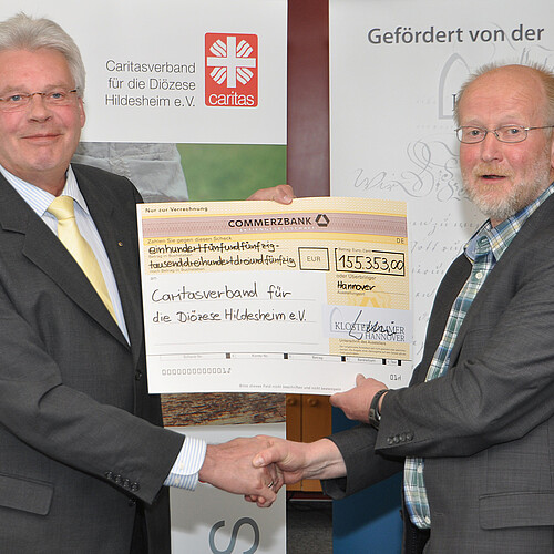 Zwei Männer, darunter Klosterkammer-Präsident Hans-Christian Biallas, halten einen symbolischen übergroßen Scheck in den Händen.