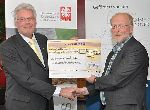 Zwei Männer, darunter Klosterkammer-Präsident Hans-Christian Biallas, halten einen symbolischen übergroßen Scheck in den Händen.