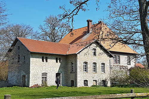 Das Molkehaus auf dem Klostergut Wiebrechtshausen mit heller Fassade und roten Dachziegeln.