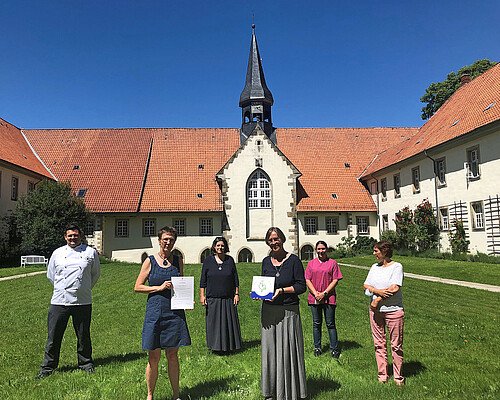 Sechs Personen stehen bei Sonnenschein im Klosterinnenhof Wülfinghausen.