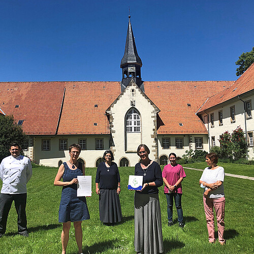 Sechs Personen stehen bei Sonnenschein im Klosterinnenhof Wülfinghausen.