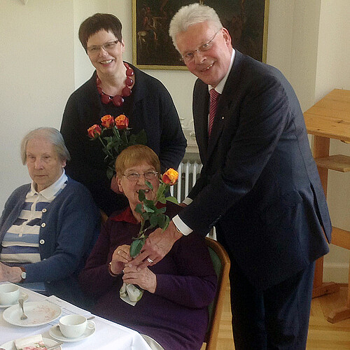 Rosemarie Meding, Äbtissin des Klosters Marienwerder und Klosterkammer-Präsident Hans-Christian Biallas überreichen zwei älteren Damen Rosen.