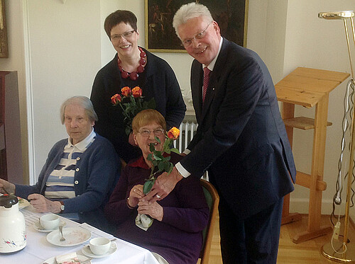 Rosemarie Meding, Äbtissin des Klosters Marienwerder und Klosterkammer-Präsident Hans-Christian Biallas überreichen zwei älteren Damen Rosen.