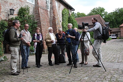 Seminar-Teilnehmer von "Click im Kloster" und Projektleiter Uwe Stelter stehen im Hof des Klosters Lüne