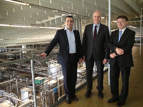 Drei Männer, darunter Andreas Hesse, Kammerdirektor der Klosterkammer Hannover, stehen in der Produktionshalle vom Harzer Grauhof Brunnen.
