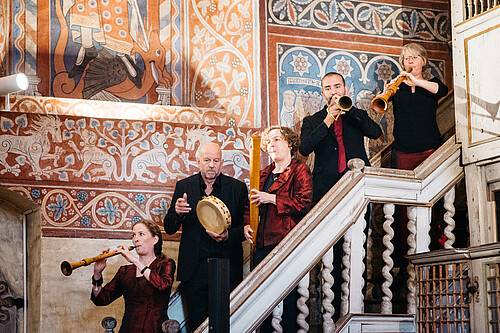 Fünf Personen, die Musikinstrumente spielen, stehen auf einer Treppe im Kloster Wienhausen.