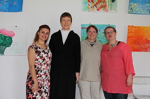 Vier Frauen, darunter Bärbel Görcke, Äbtissin des Klosters Mariensee, stehen vor einer Wand mit selbstgemalten Bildern.