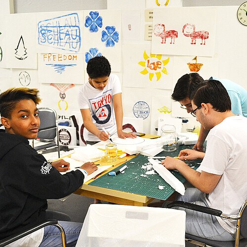 Schüler und Jugendliche erarbeiten in mit unterschiedlichen Materialien Gegenstände für eine Ausstellung.