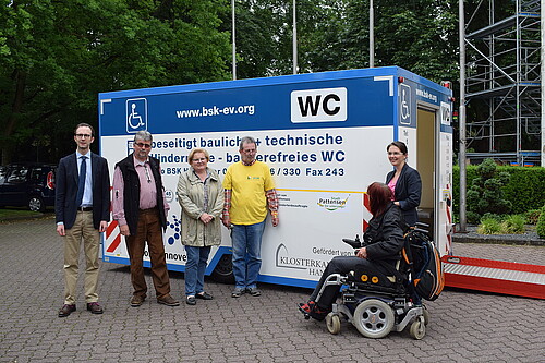Vor einem Toilettenwagen befinden sich drei Männer - darunter Bastian Pielczyk, Dezernent Förderungen der Klosterkammer - und zwei Frauen sowie eine Person im Rollstuhl.