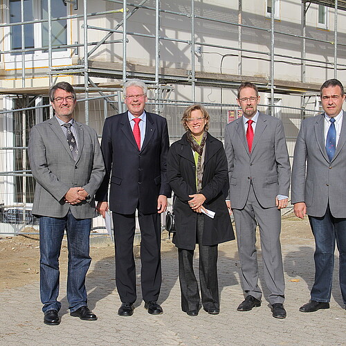 Eine Frau und vier Männer, darunter Klosterkammer-Präsident Hans-Christian Biallas, stehen vor einem Baugerüst.