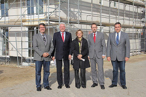 Eine Frau und vier Männer, darunter Klosterkammer-Präsident Hans-Christian Biallas, stehen vor einem Baugerüst.