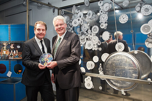 Zwei Männer, darunter Klosterkammer-Präsident Hans-Christian Biallas, halten eine Uhr.