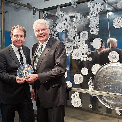 Zwei Männer, darunter Klosterkammer-Präsident Hans-Christian Biallas, halten eine Uhr.