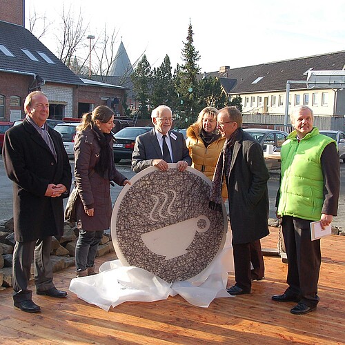 Zwei Frauen und vier Männer halten auf dem Gelände der Goslarschen Höfe eine übergroße Tasse als Schriftzug für das neue Hof-Café.