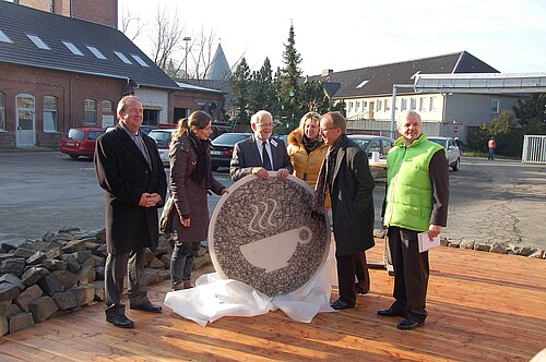 Zwei Frauen und vier Männer halten auf dem Gelände der Goslarschen Höfe eine übergroße Tasse als Schriftzug für das neue Hof-Café.