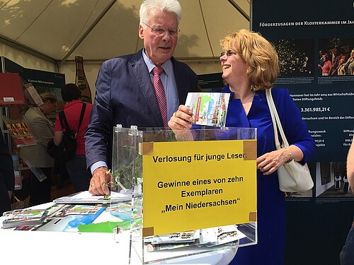 Tag der Niedersachsen 2015: Eine Frau und ein Mann, darunter Klosterkammer-Präsident Hans-Christian Biallas, stehen hinter einer Los-Box.