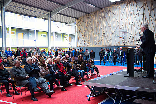 Auf einem Podest steht Klosterkammer-Präsident Hans-Christian Biallas und spricht zu den Gästen der Sporthallen-Eröffnung in dem neuen Gebäude.