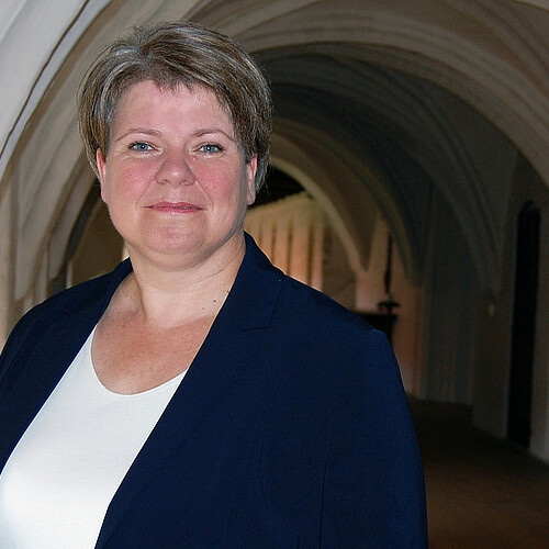 Frau vor Kirchengewölbe