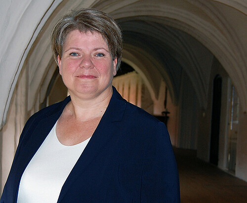 Frau vor Kirchengewölbe