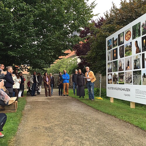 Eine Gruppe von Personen, darunter Schwester Reinhild von Bibra, Äbtissin des Klosters Wülfinghausen, steht vor einer Fotowand zum Workshop Click im Kloster.