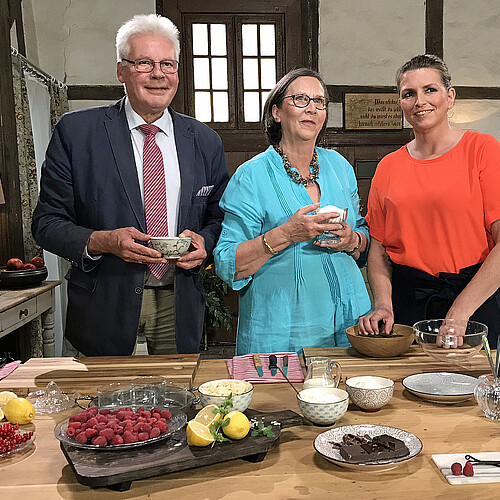 Ein mann und zwei Frauen stehen in einer für den Dreh der Serie Klosterküche eingerichteten historischen Küche im Kloster Wienhausen.