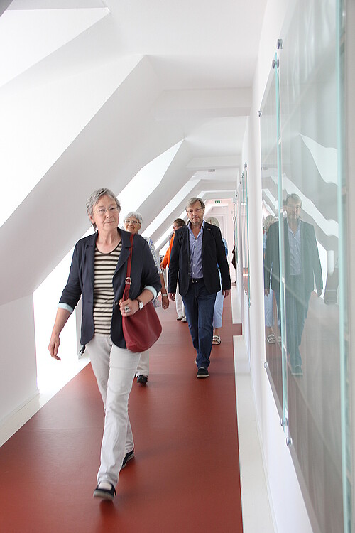 Vier Frauen und Reiner Dittmann, Bauleiter der Klosterkammer, laufen einen Gang im Kloster Barsinghausen entlang.