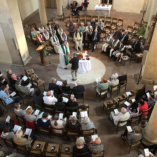 Blick von oben auf einen Runden Kirchinnenraum, wo ein Gottesdienst gefeiert wird.