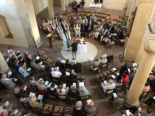 Blick von oben auf einen Runden Kirchinnenraum, wo ein Gottesdienst gefeiert wird.