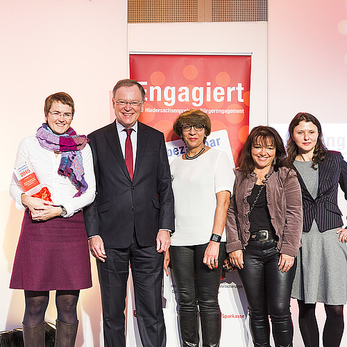 Ein Mann und vier Frauen stehen vor einem Roll-Up.
