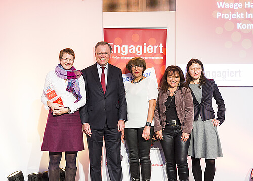 Ein Mann und vier Frauen stehen vor einem Roll-Up.